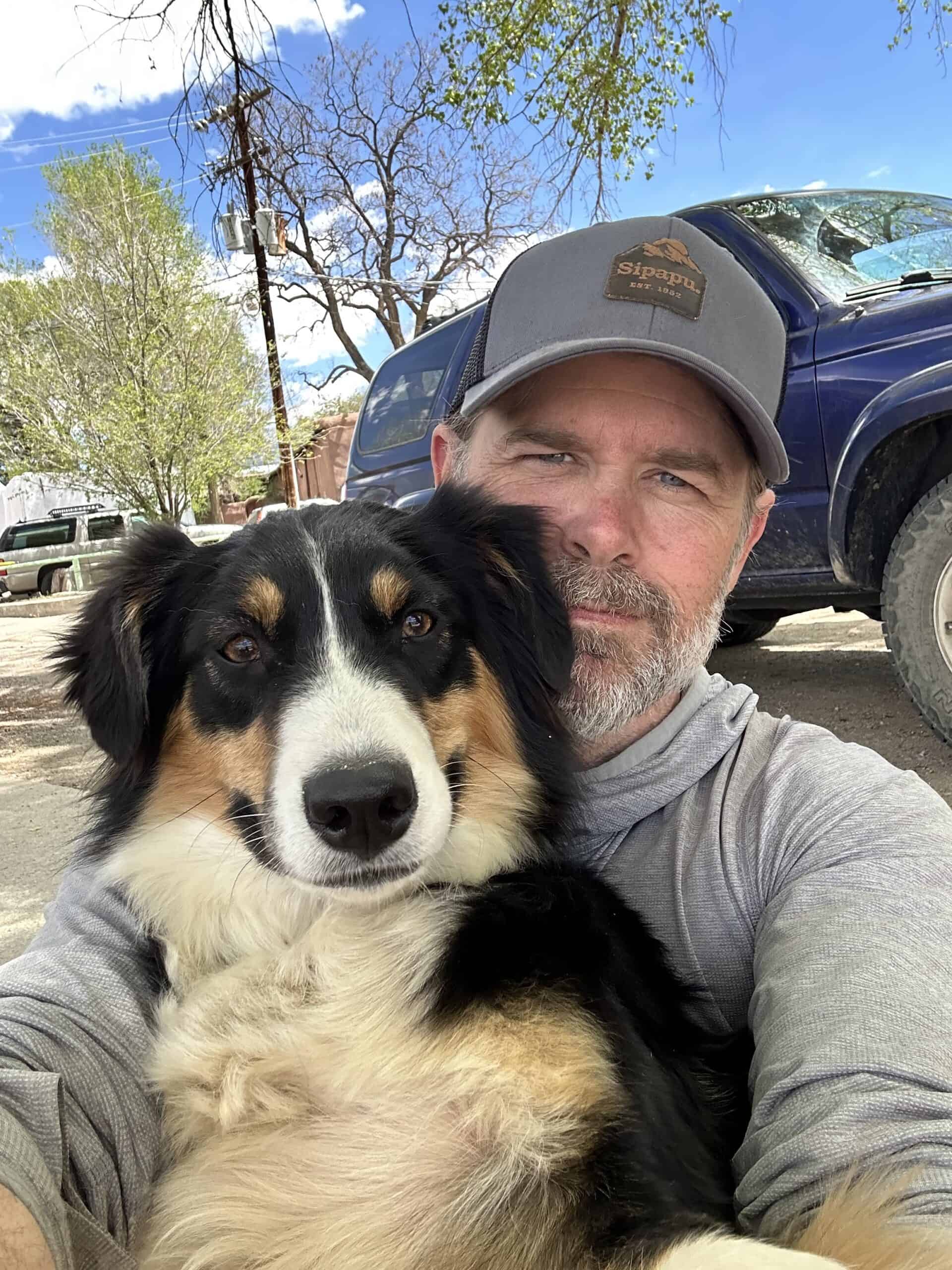 Man with dog outdoors during Santa Fe to Taos Thru-Hike adventure.